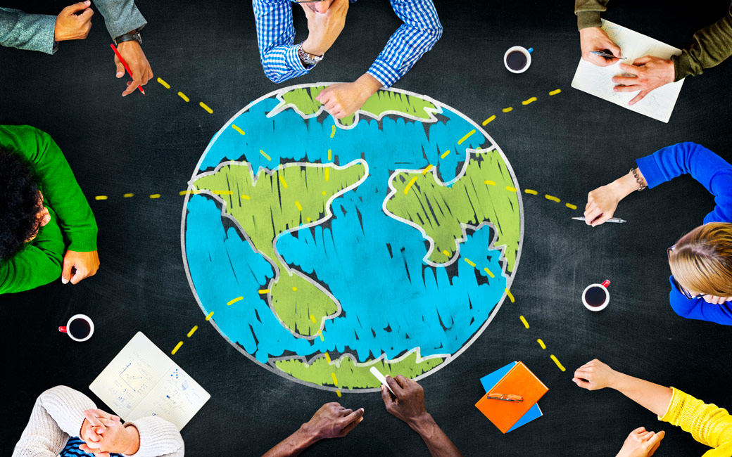 Aerial view of people collaborating around a table with a chalk globe