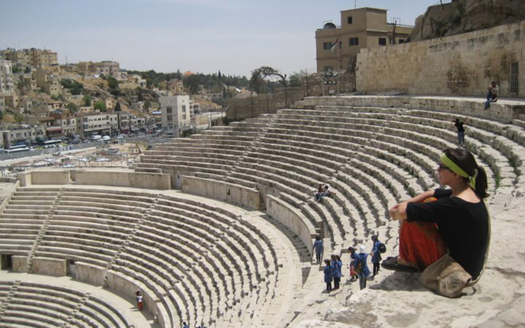 Student contemplating ancient mediterranean historical site