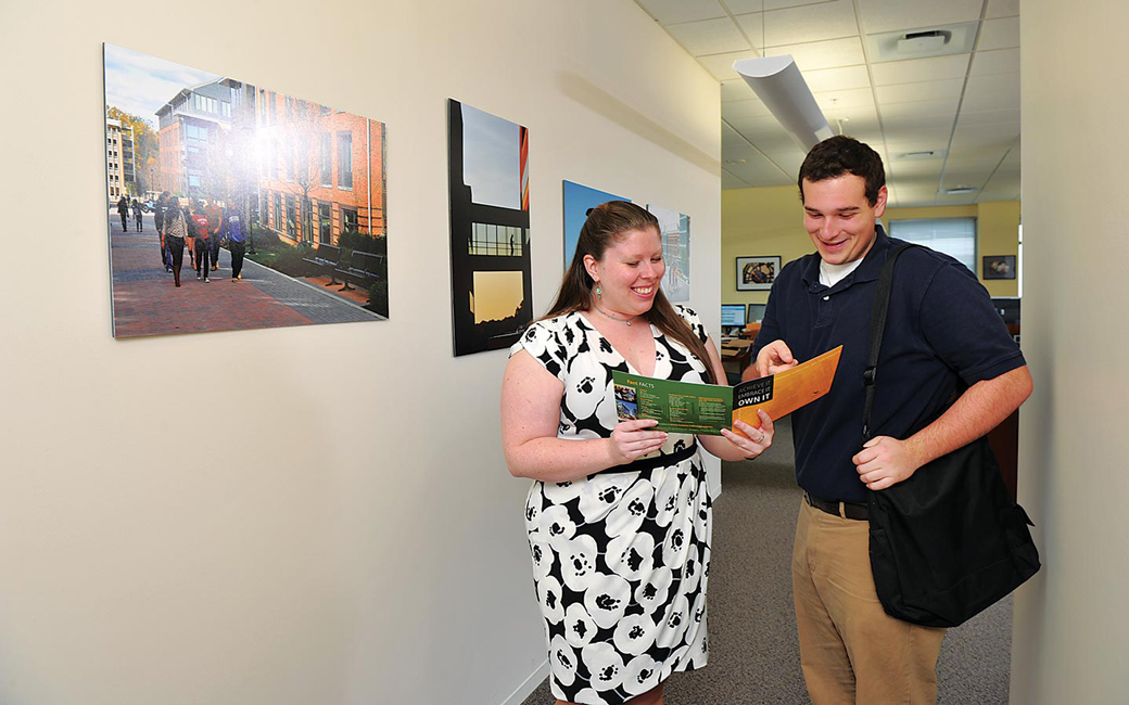 Student worker and staff member reviewing brochure