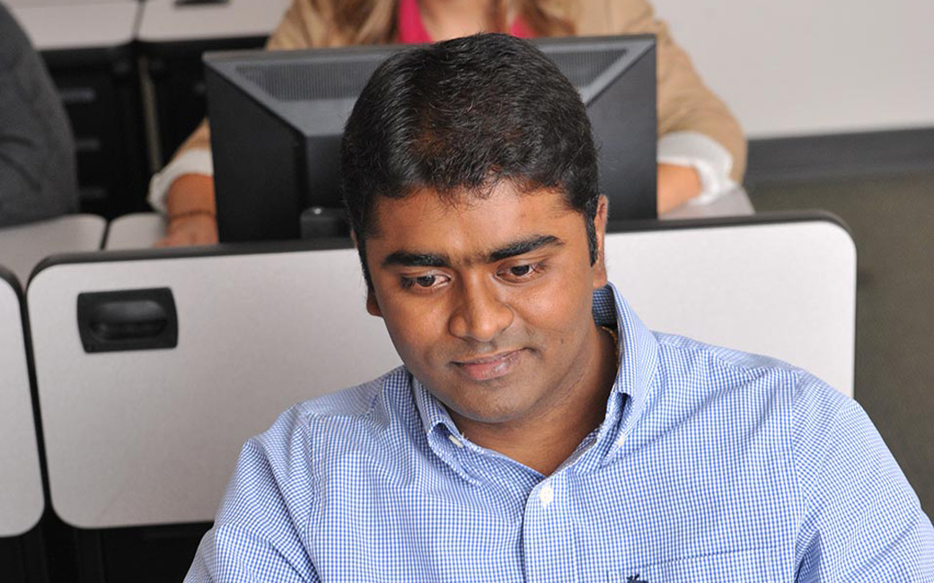 Student sitting at desk conducting a job search on a computer