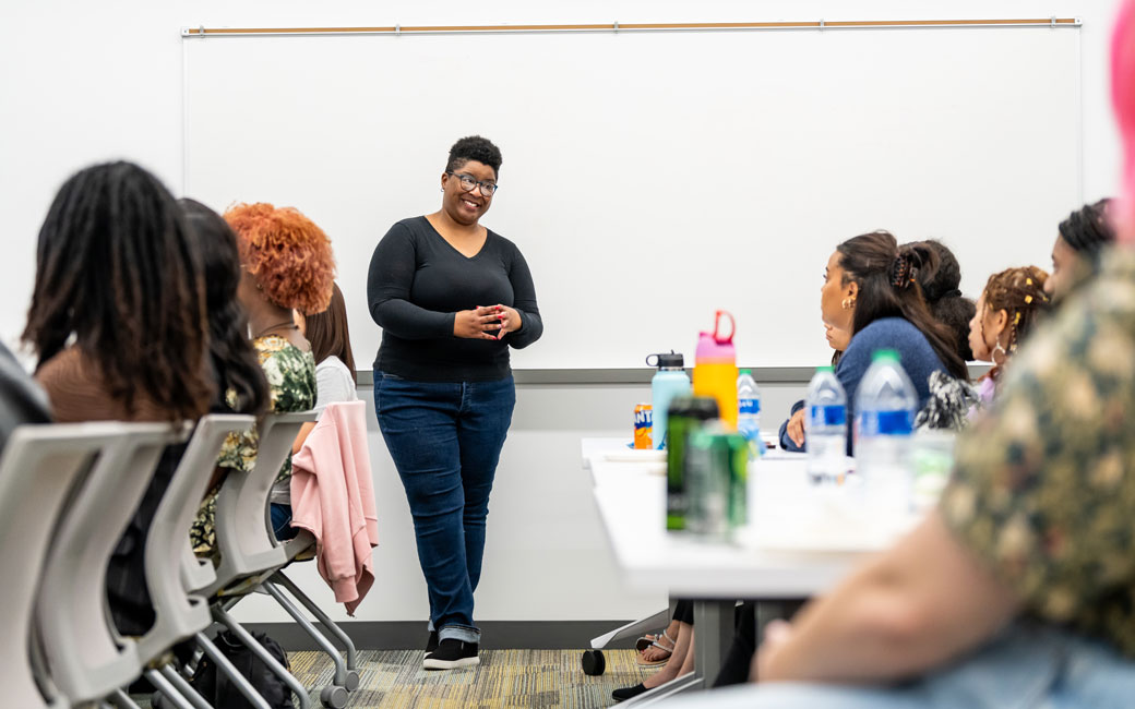 A female mentor speaks with a group of mentees