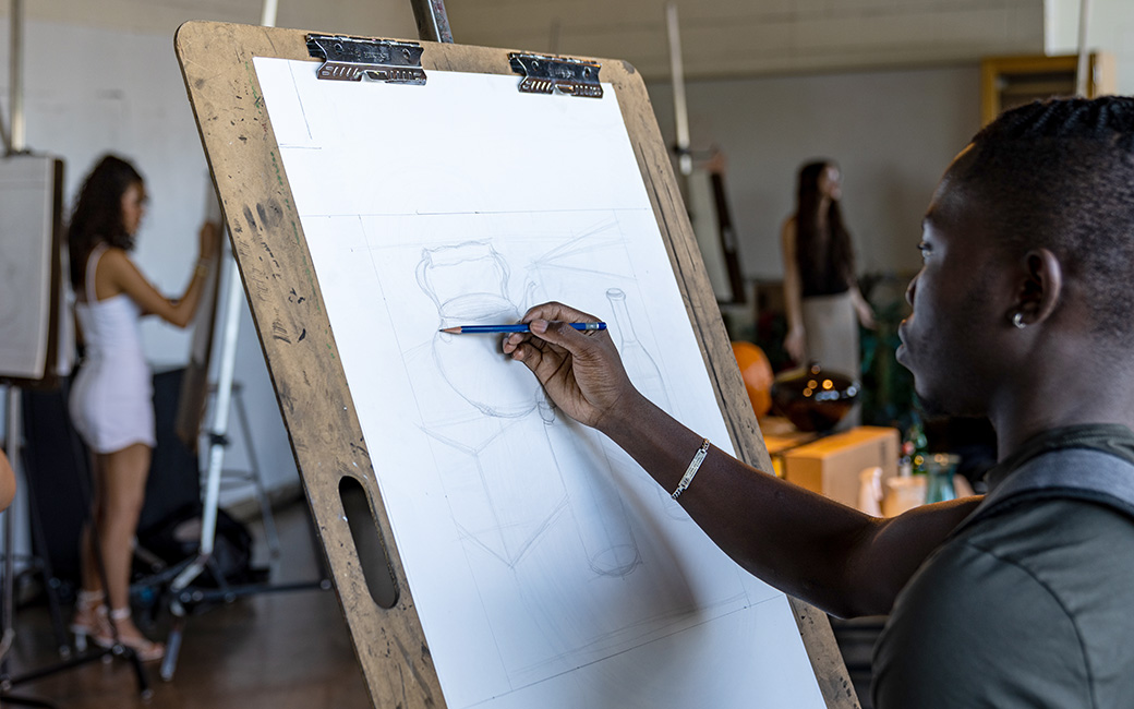 student (male) drawing in drawing studio class