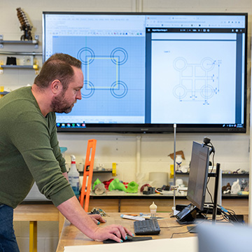 faculty member demonstrating 3D sofware on projected screen in computer lab