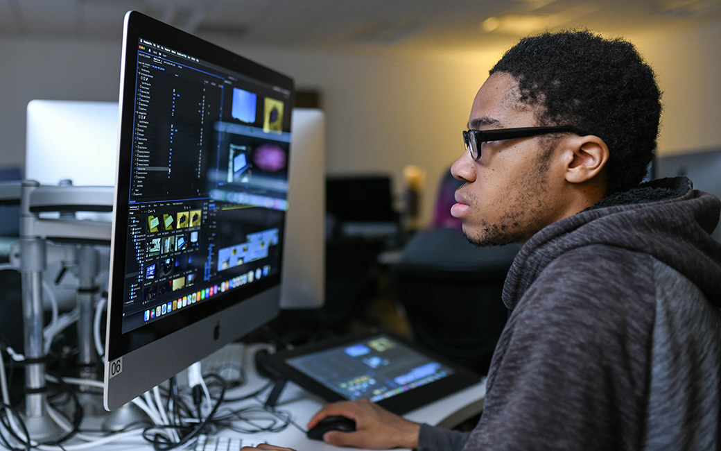 Student working on computer in video class