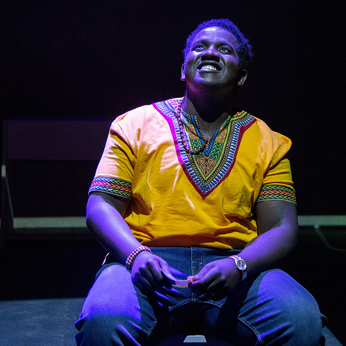 Student Smiling and looking up in stage lights