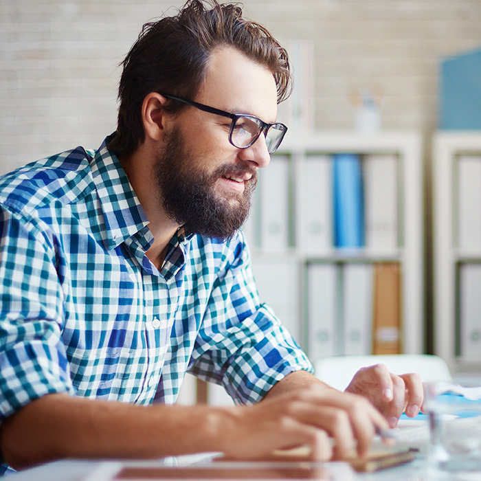 caucasian bearded man working on laptop