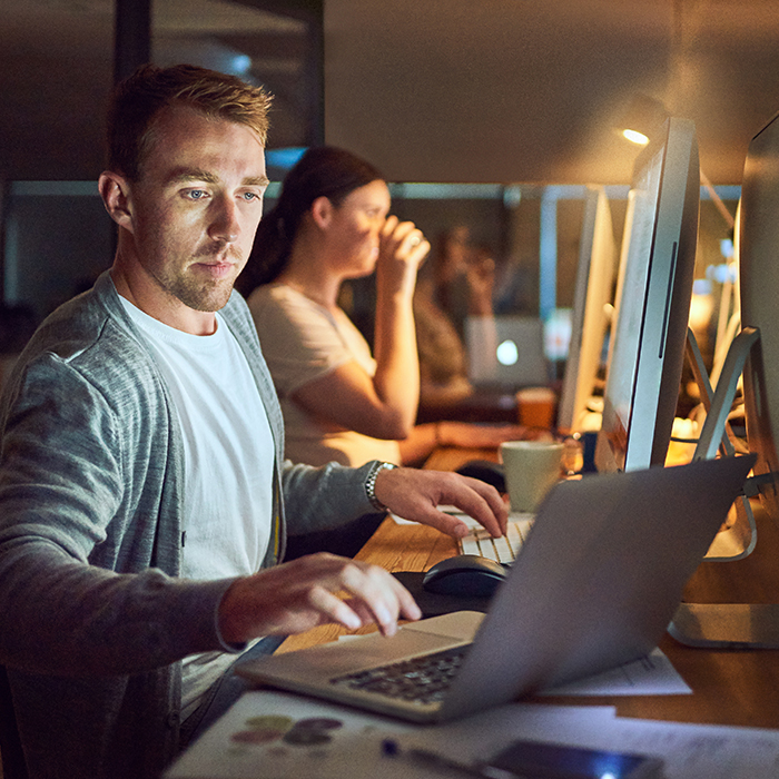 caucasian man working a computer in the night