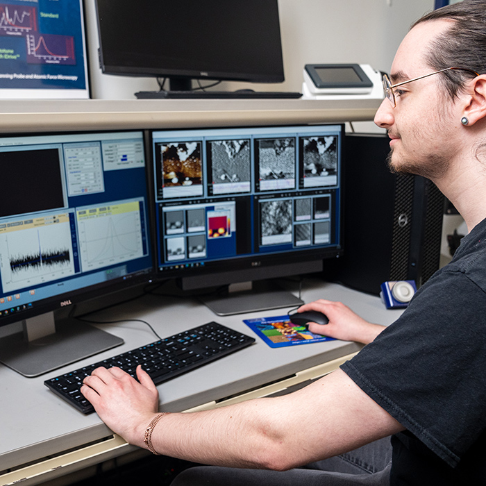 student in front of computer screens