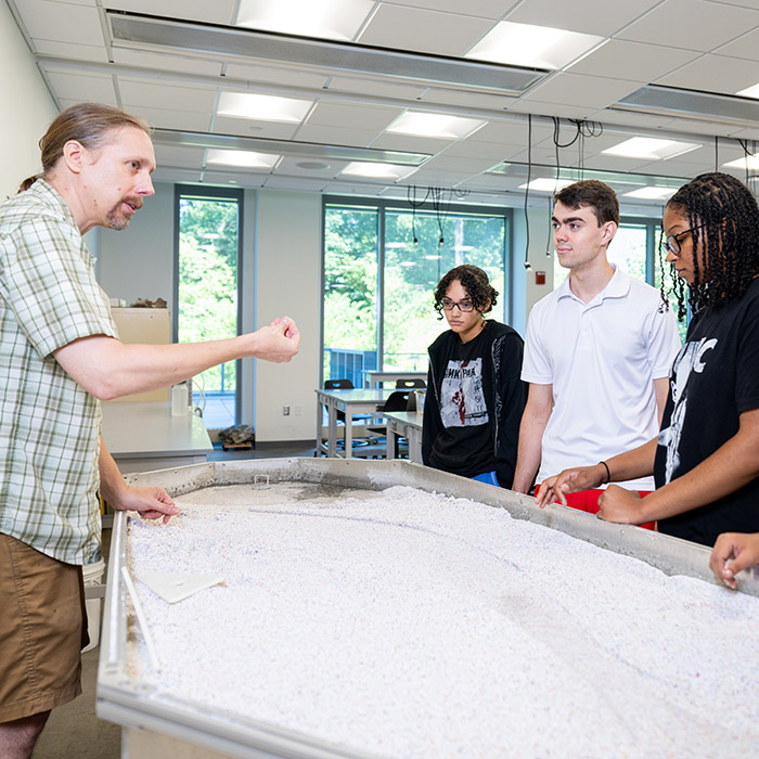 Professor Eriks Perkons teaching his Physical Geology class (GEOL 121) about stream flow and groundwater flow