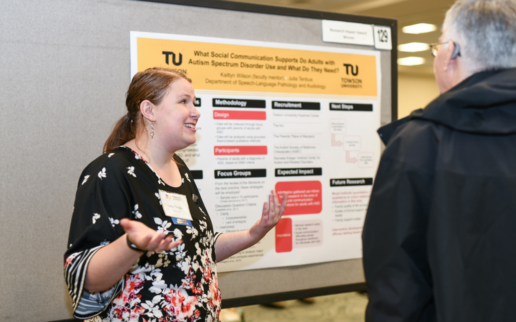 Honors student standing in front of poster describing experiential learning