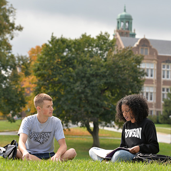 two students sitting on campus quad