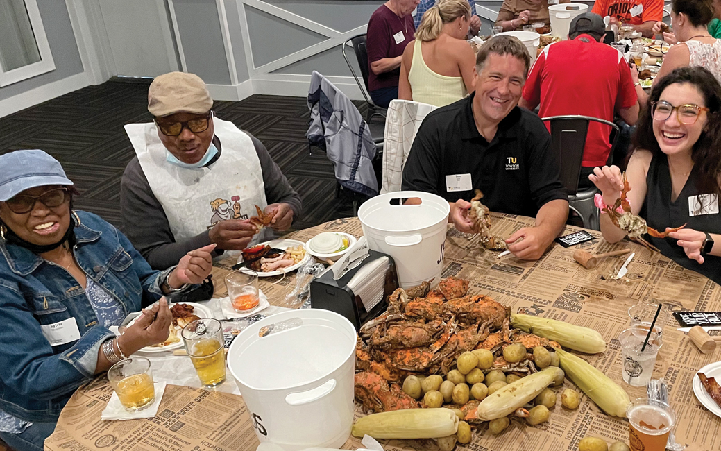 A group of people sitting at table picking crabs
