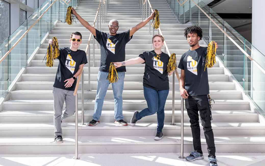 Group of four students jumping for joy