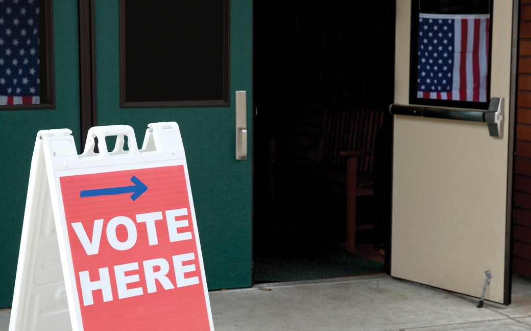 an open door with a voting placard in front