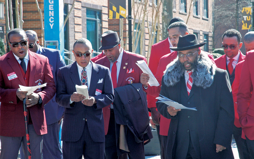 Members of Lambda Zeta sing “In the Year 1911” in West Village.