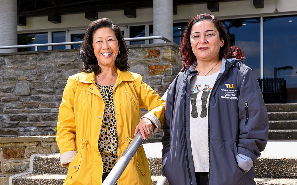 Two women stand outside on steps