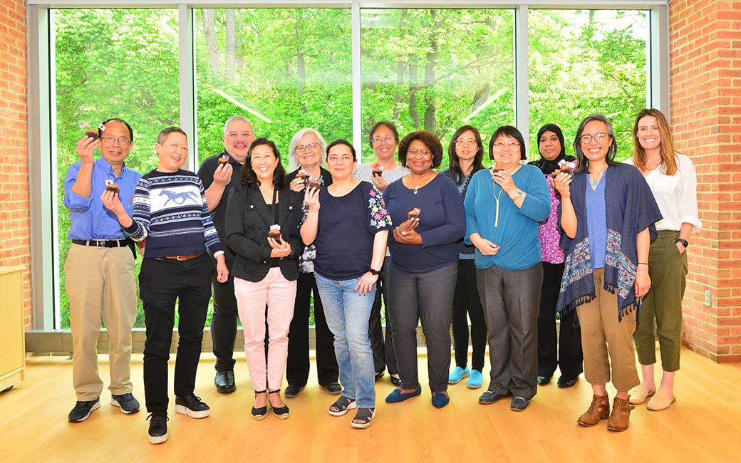 Group of people pose holding cupcakes