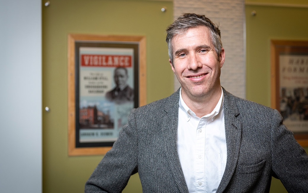 Portrait with book cover poster in background