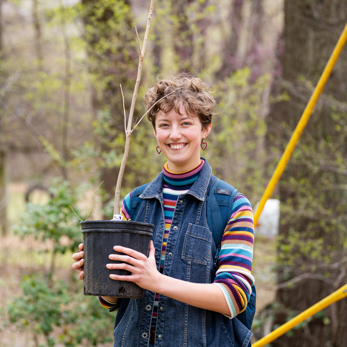 A student holding a tree 