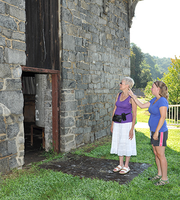 Two women next to a stone building
