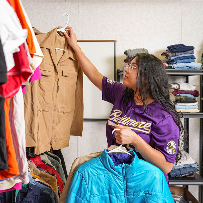 Student sifts through clothing closet within the Basic Needs Hub on campus