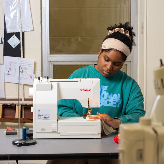 Students sews on Bernina sewing machine