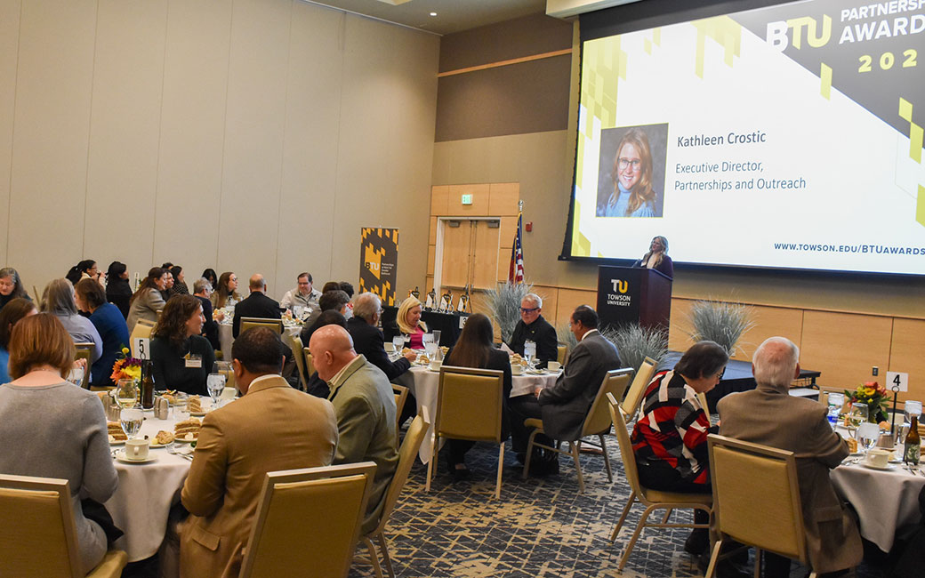 Kathleen Crostic at podium speaking to dinner guests