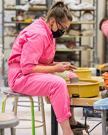 Person working at pottery wheel