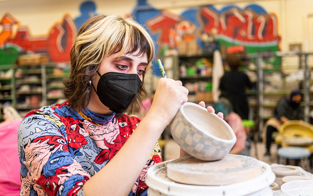 Student working on clay bowl