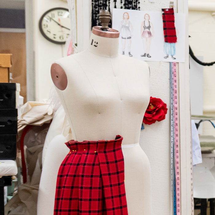 Dress form in the costume shop with flannel printed fabric pinned to the waist