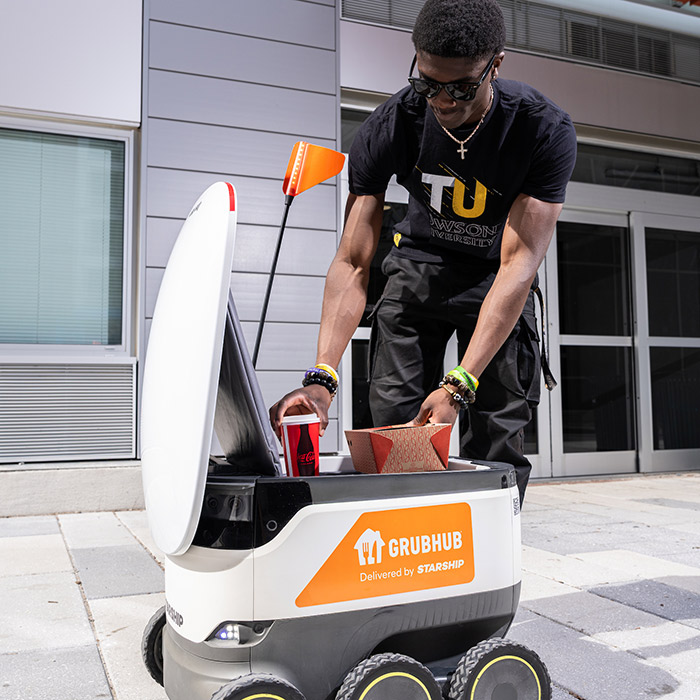 TU student using the food delivery robot