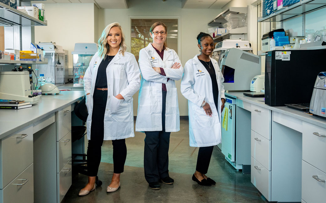 professor and 2 students in lab