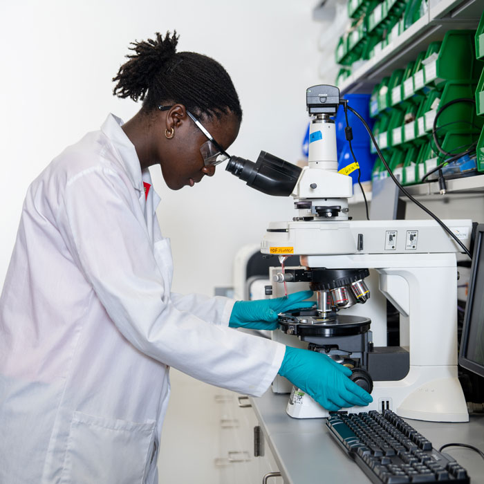 Lloyce Frimpong looking into a microscope