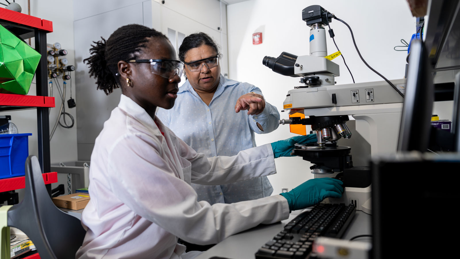 Lloyce Frimpong and Mary Devadas go over research in a Science Complex lab