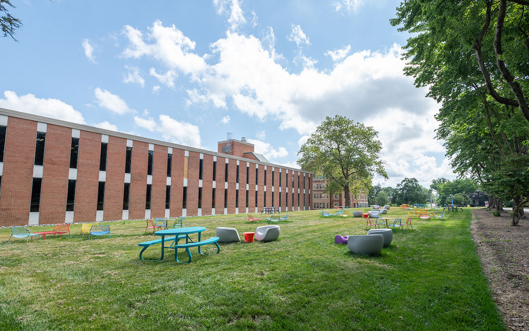Colorful outdoor furniture in grassy area by library