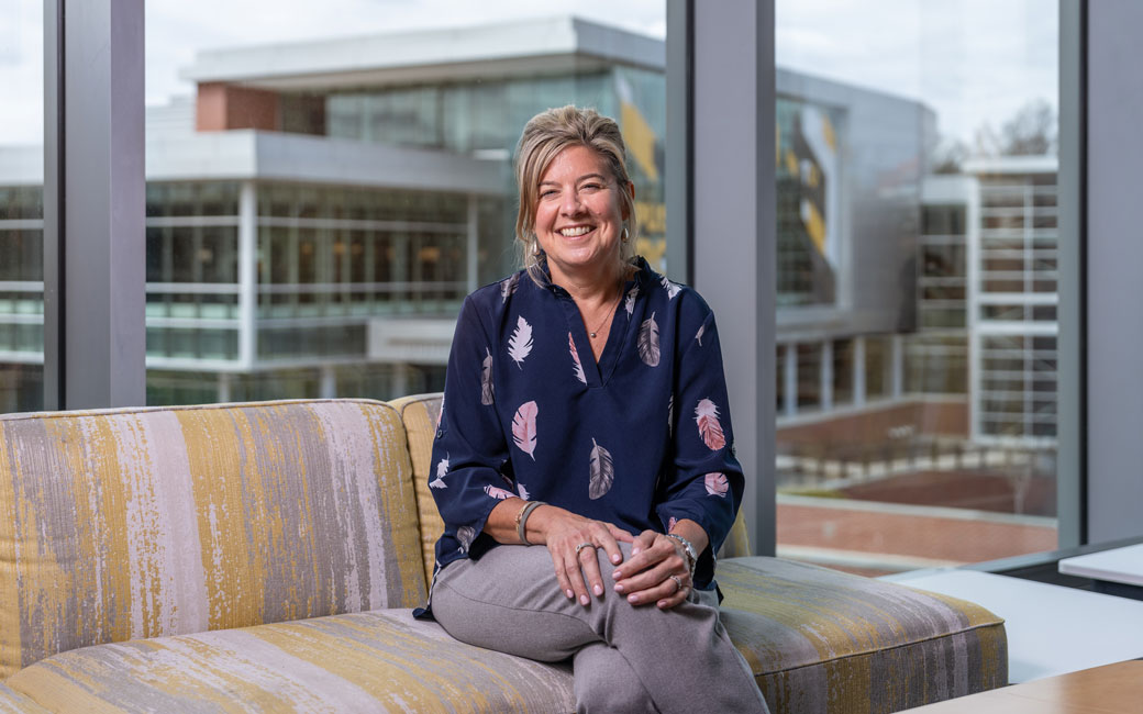 Woman sits in the University Union overlooking Burdick Hall