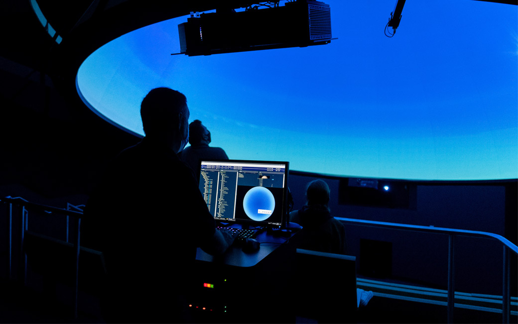 A professor backlit in the planetarium of the new Science Complex