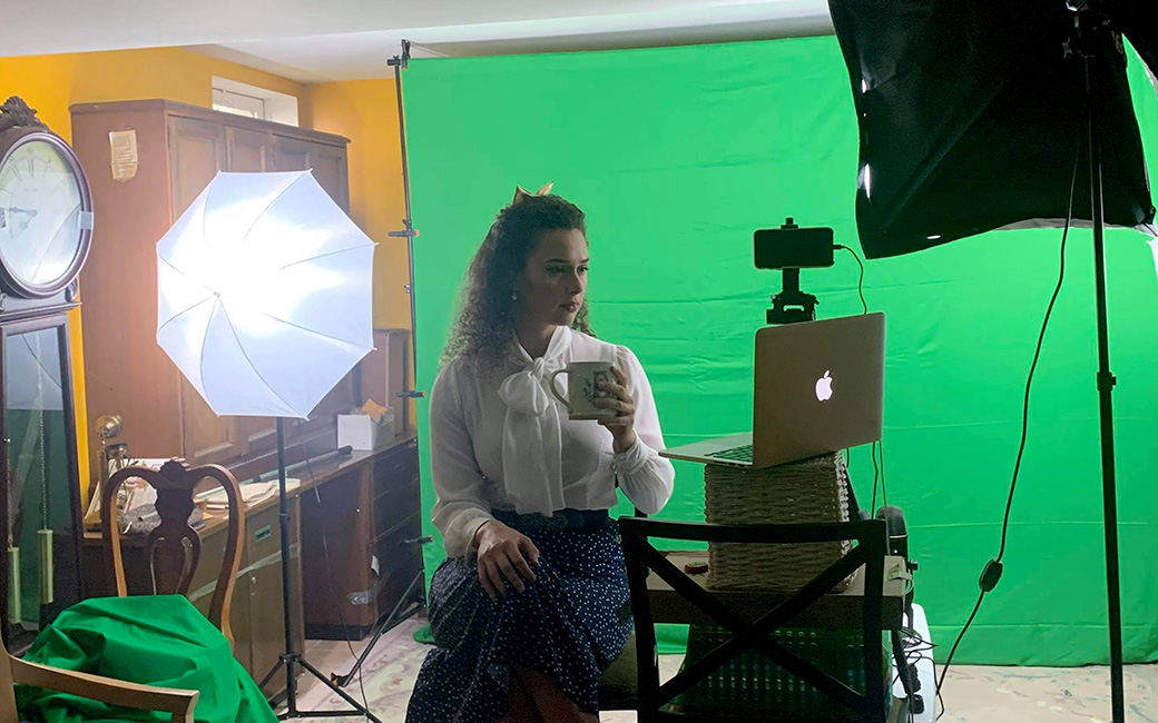 Shereen Ahmed at home studio in front of computer and greenscreen