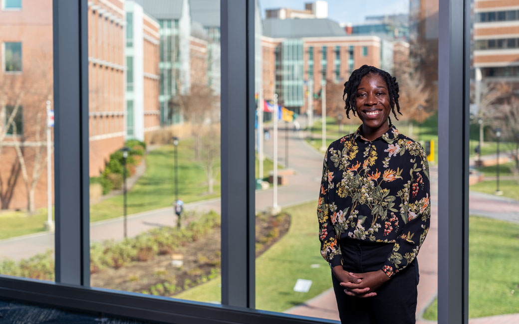 woman professor stands in university union overlooking international walkway