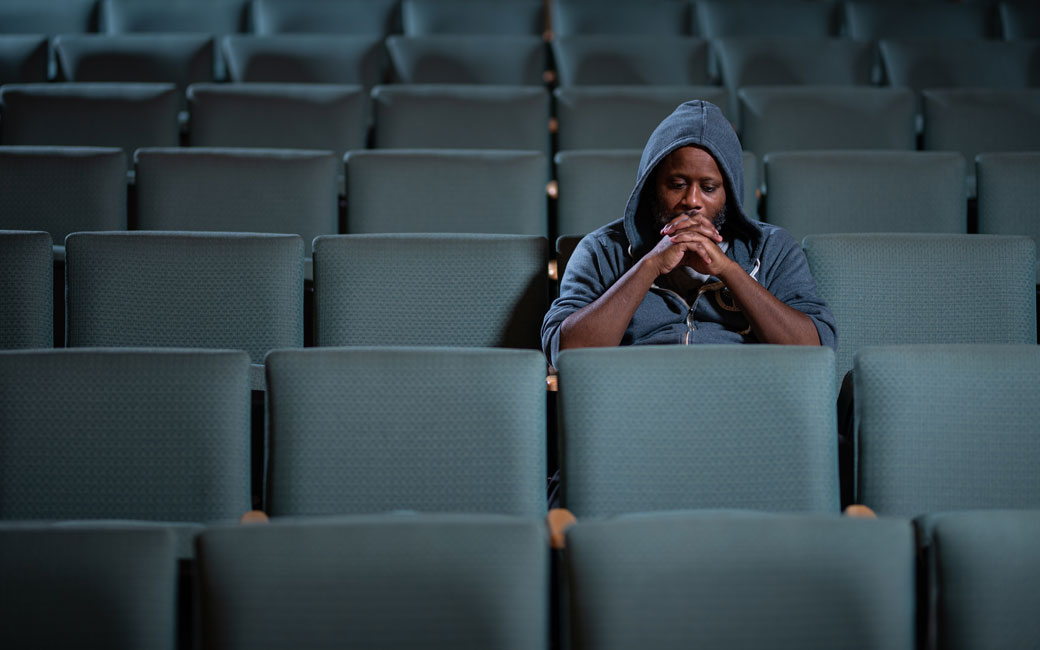 Shodekeh sitting in seats, by himself