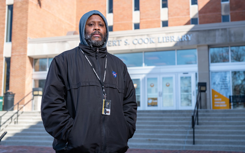 Shodekeh standing in front of Albert S. Cook Library