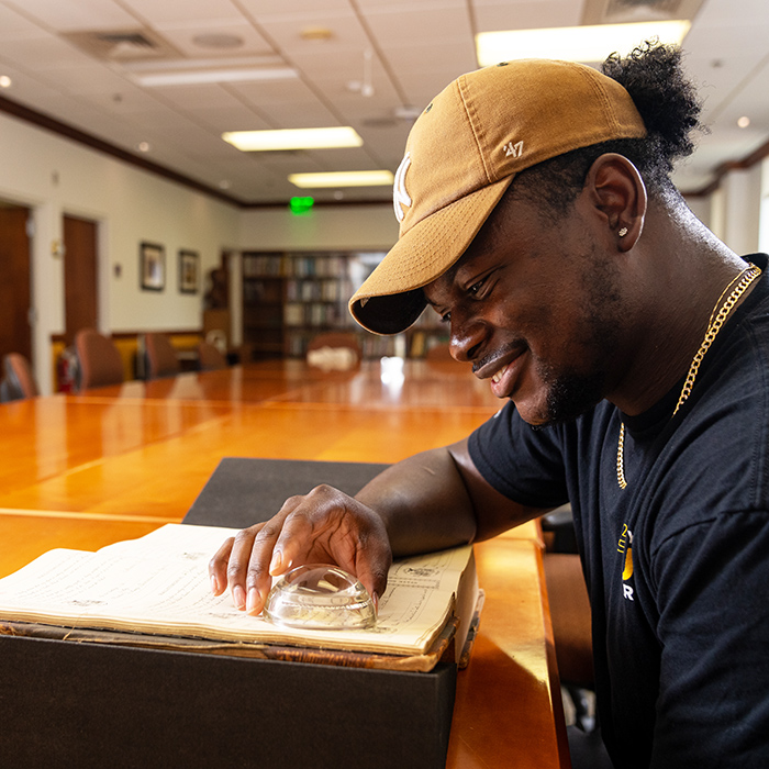 male student reading a history book