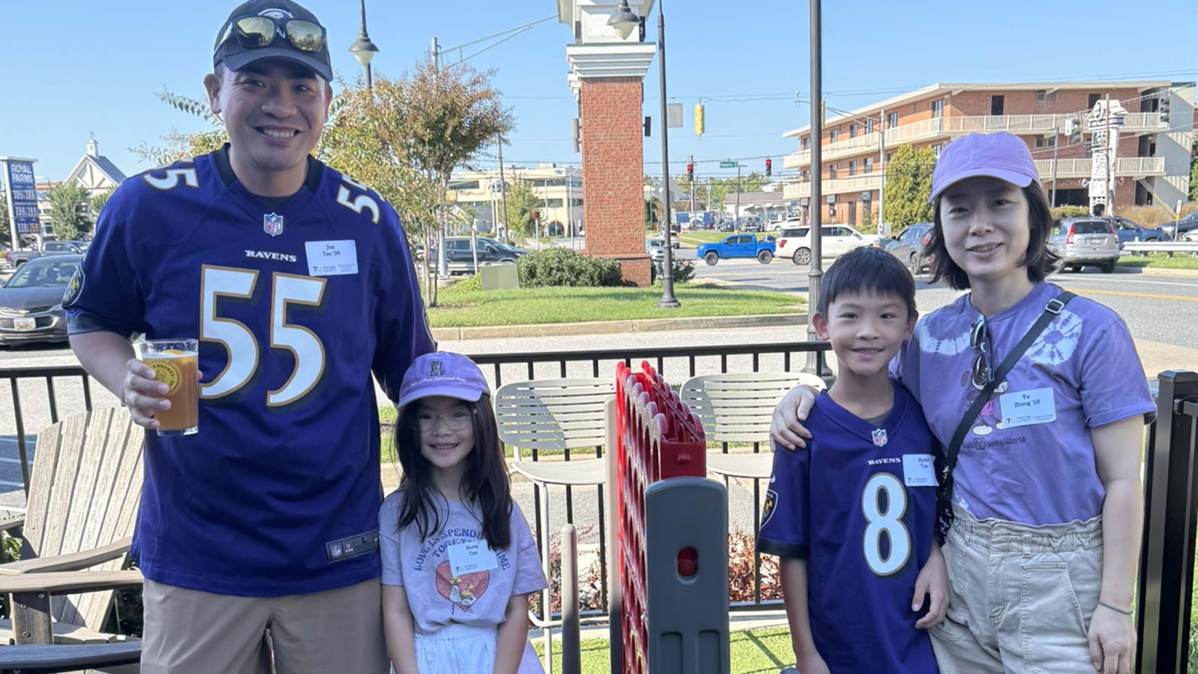 Jun Tao ’09 and Yvonne Zhang ’09 cheer on the Ravens with their family at the watch party.