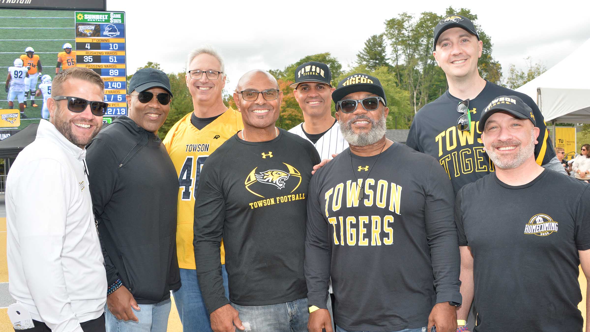 Alumni, including several former football team members, return to cheer on the current squad.
