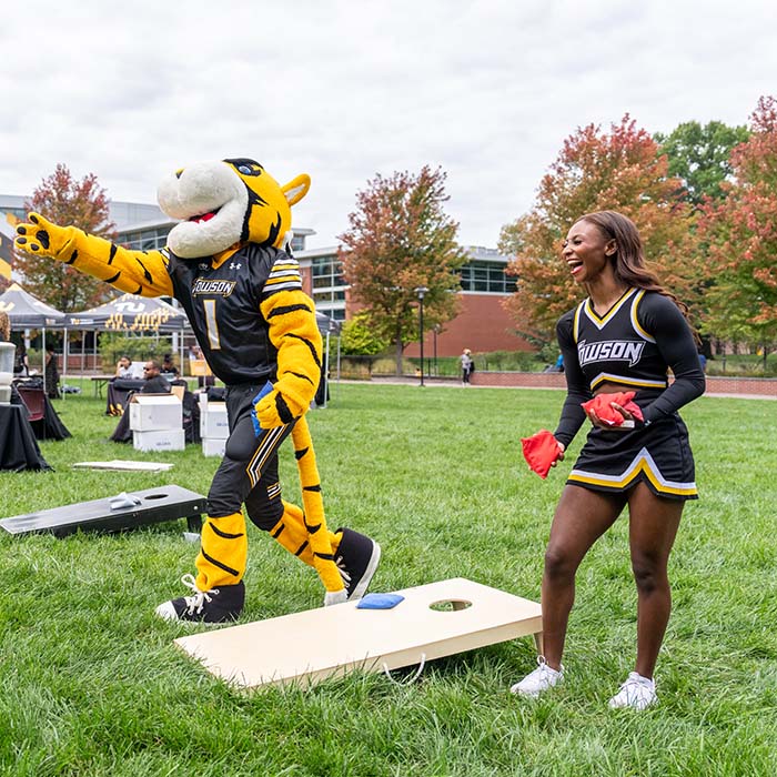 Doc and a cheerleader playing cornhole