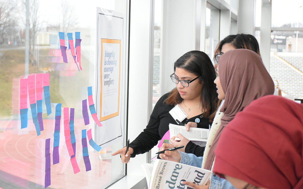 Young women put stickey notes on window