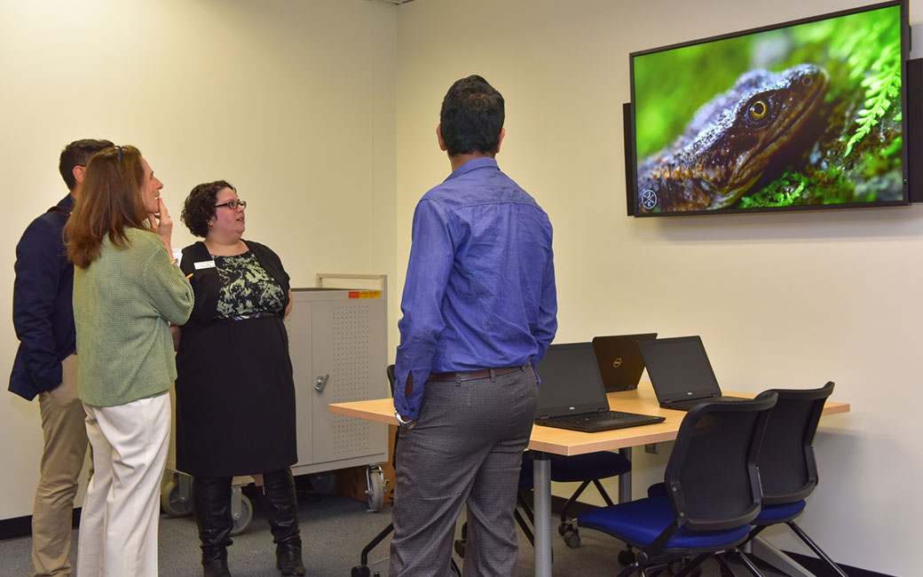 FACET Active Learning Lab Ribbon Cutting. Attendees discussing technologies included within the lab.