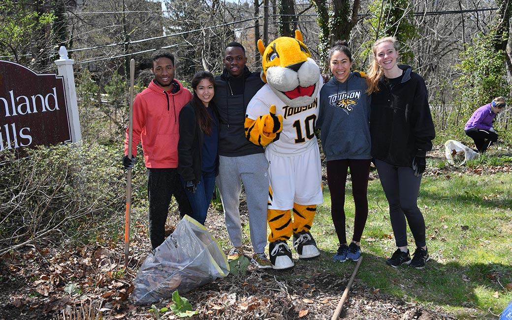 Doc and students rake leaves. 